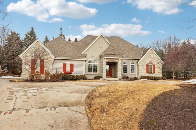 french provincial home with stone siding and roof with shingles