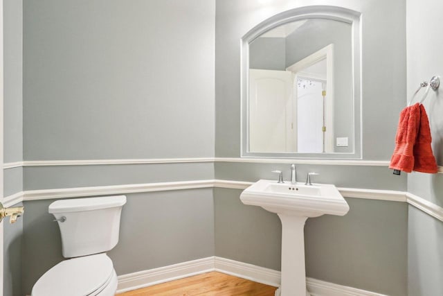 bathroom featuring baseboards, toilet, and wood finished floors