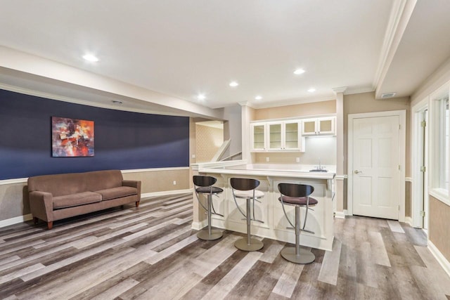 kitchen with light countertops, light wood-style flooring, white cabinetry, and a kitchen breakfast bar