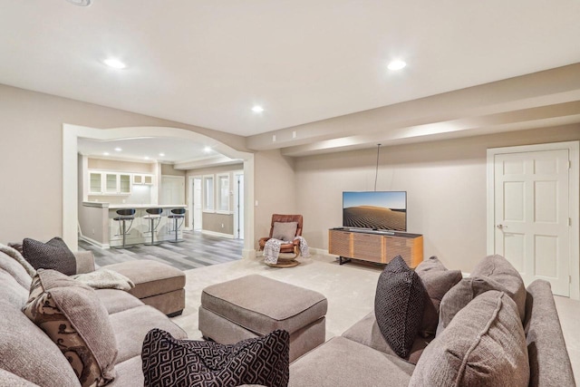 living room featuring arched walkways, baseboards, and recessed lighting