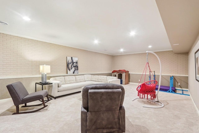 carpeted living area with brick wall, baseboards, crown molding, and recessed lighting