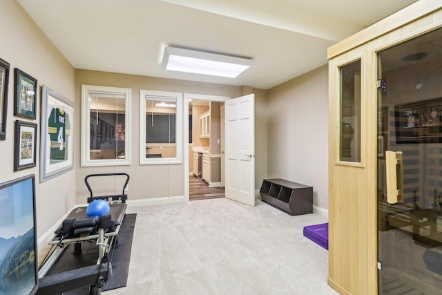 exercise room with carpet and baseboards