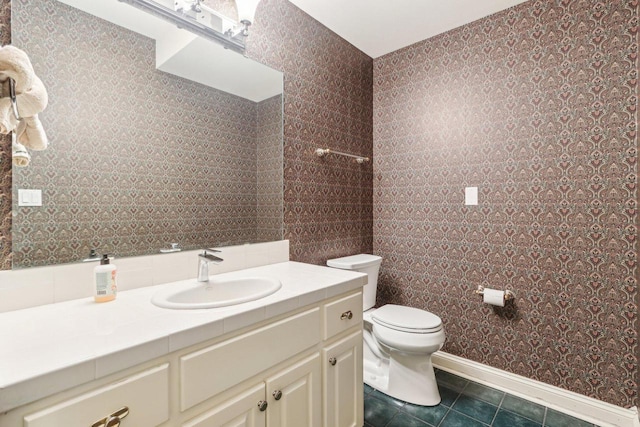 bathroom with baseboards, vanity, toilet, and tile patterned floors