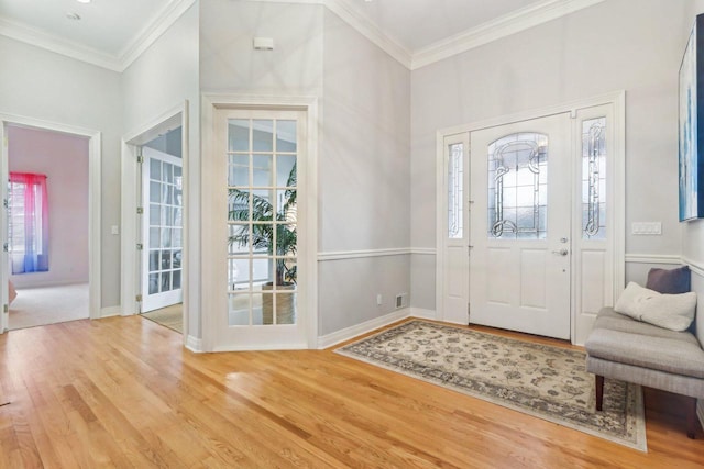 entryway featuring crown molding, baseboards, and wood finished floors