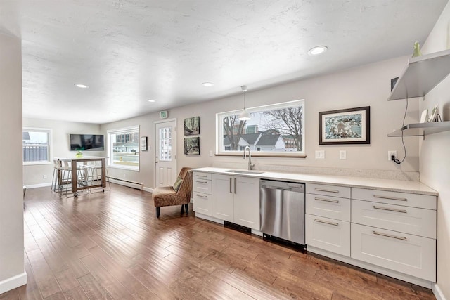 kitchen featuring dark wood-style floors, a baseboard radiator, light countertops, stainless steel dishwasher, and a sink