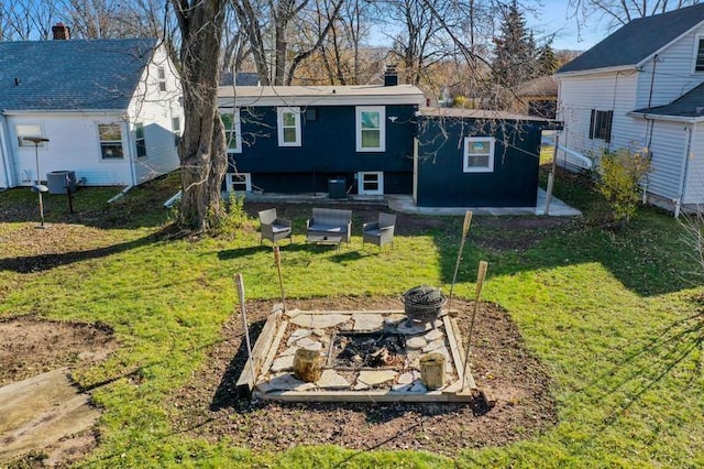 rear view of house with a chimney, a vegetable garden, and a yard