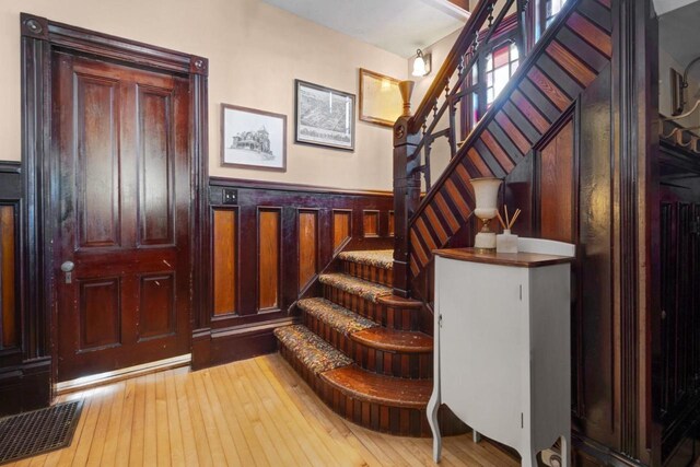205 State St, Ripon, WI 54971 - stairway featuring a wainscoted wall, hardwood / wood-style flooring, and visible vents