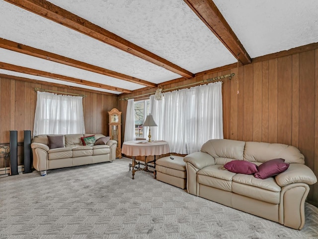 carpeted living area featuring a textured ceiling, wooden walls, and beam ceiling