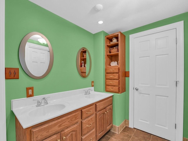 bathroom featuring a sink, baseboards, and double vanity