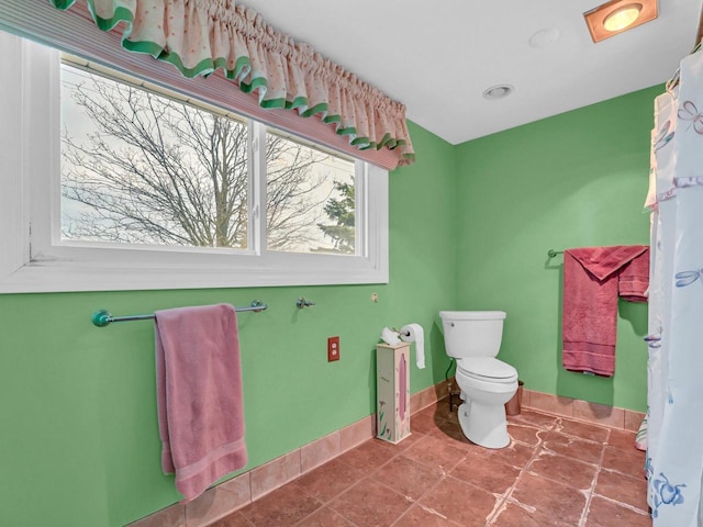 bathroom with toilet, tile patterned flooring, and baseboards