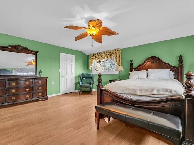 bedroom with lofted ceiling, light wood finished floors, a ceiling fan, and baseboards