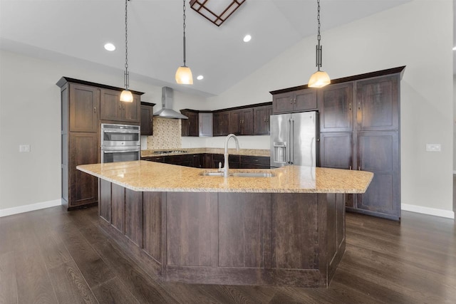 kitchen featuring a sink, appliances with stainless steel finishes, dark wood-type flooring, and wall chimney range hood