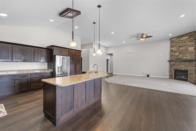 kitchen with dark wood-style floors, ceiling fan, high quality fridge, dark brown cabinets, and a sink