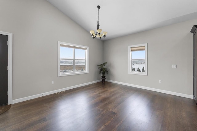 empty room with dark wood-style flooring, visible vents, vaulted ceiling, a chandelier, and baseboards