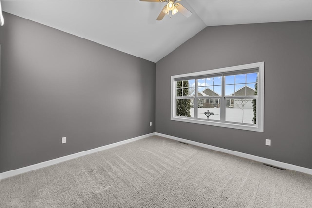 empty room featuring vaulted ceiling, carpet, visible vents, and baseboards