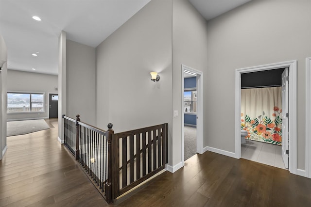 hallway featuring recessed lighting, wood finished floors, an upstairs landing, and baseboards