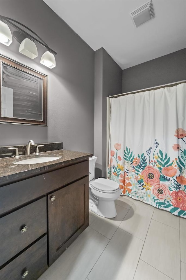 bathroom with toilet, tile patterned flooring, vanity, and visible vents