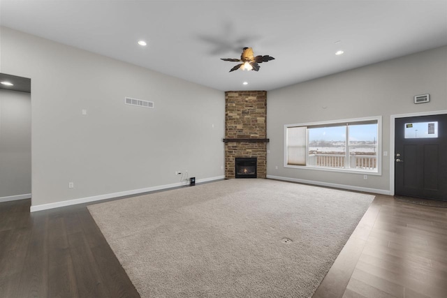 unfurnished living room with a brick fireplace, dark wood-style floors, baseboards, and recessed lighting