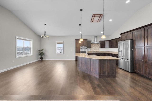 kitchen with dark wood-style flooring, stainless steel appliances, a sink, dark brown cabinetry, and an island with sink