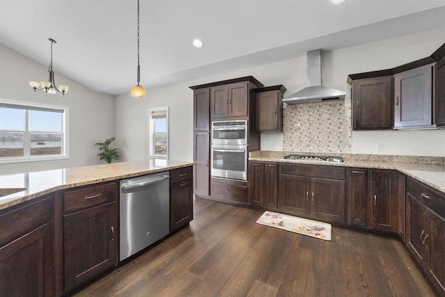 kitchen featuring lofted ceiling, stainless steel appliances, dark wood-type flooring, dark brown cabinets, and wall chimney range hood