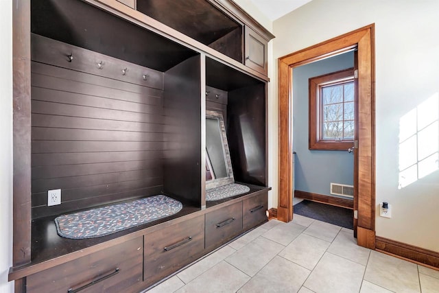 mudroom with a healthy amount of sunlight, light tile patterned floors, baseboards, and visible vents