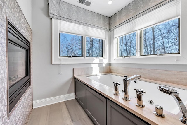 full bath with a garden tub, baseboards, and visible vents