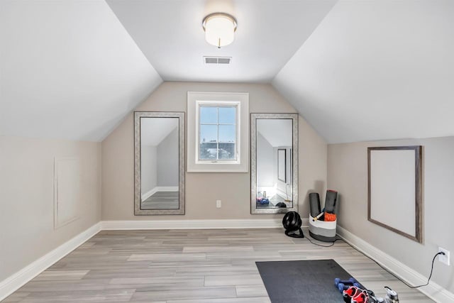 bonus room featuring visible vents, vaulted ceiling, baseboards, and wood finished floors