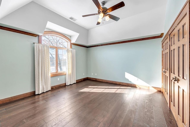 spare room featuring wood-type flooring, visible vents, and baseboards