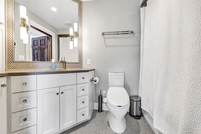 bathroom with toilet, visible vents, baseboards, vanity, and tile patterned floors