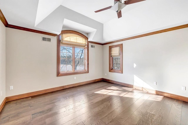 unfurnished room with baseboards, visible vents, and hardwood / wood-style floors