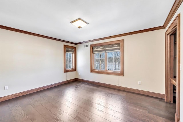 empty room with visible vents, baseboards, and hardwood / wood-style flooring