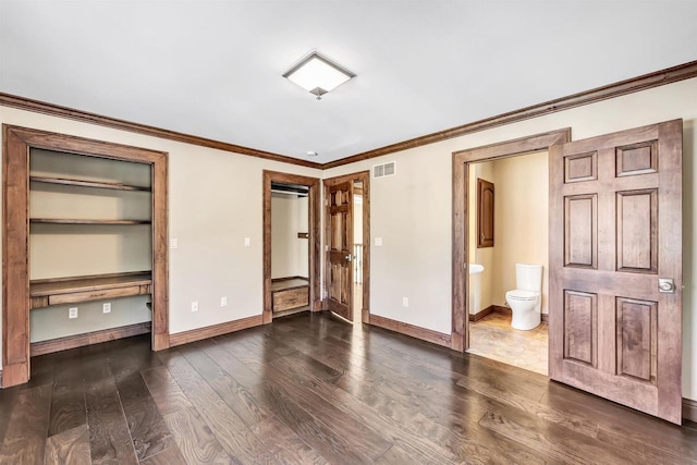 unfurnished bedroom with crown molding, baseboards, dark wood-style flooring, and ensuite bathroom