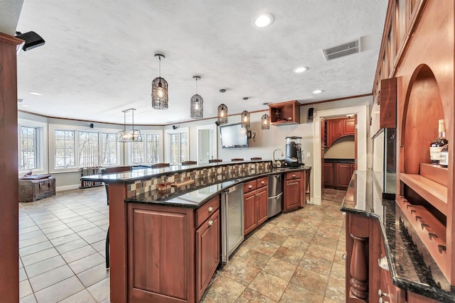 kitchen with crown molding, visible vents, dark stone counters, and a textured ceiling