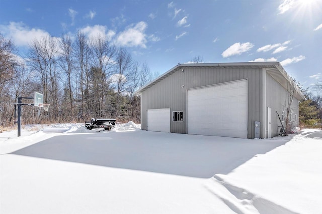 snow covered garage featuring a garage