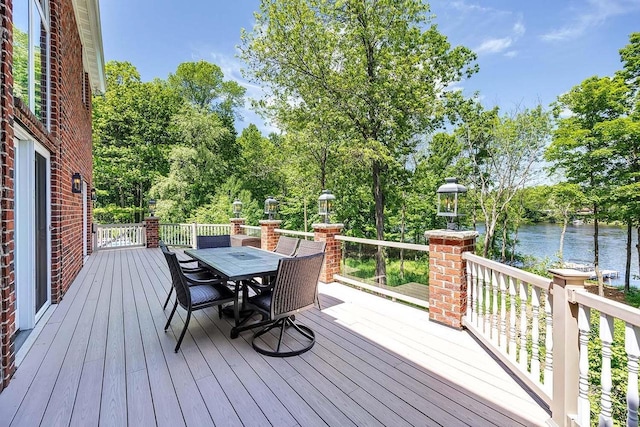 wooden deck with outdoor dining area and a water view