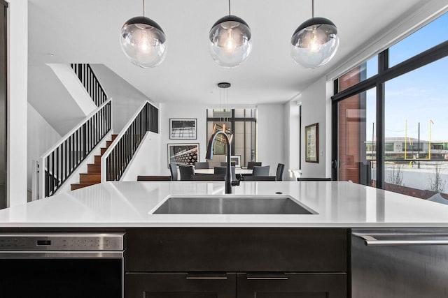 kitchen featuring light countertops, dishwasher, and a sink