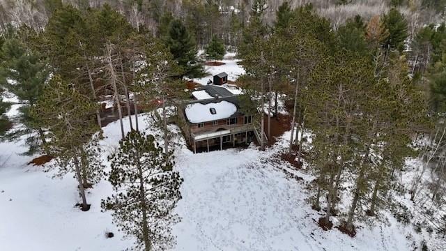 snowy aerial view with a wooded view