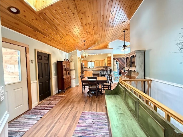 interior space featuring lofted ceiling, wooden ceiling, and a wainscoted wall