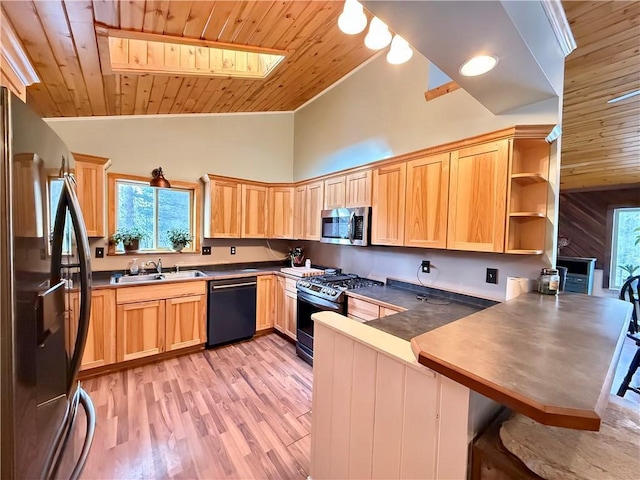 kitchen with stainless steel appliances, light brown cabinets, a sink, and a peninsula