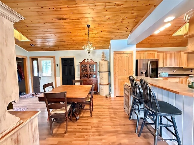 dining space featuring light wood-style floors, wooden ceiling, and vaulted ceiling