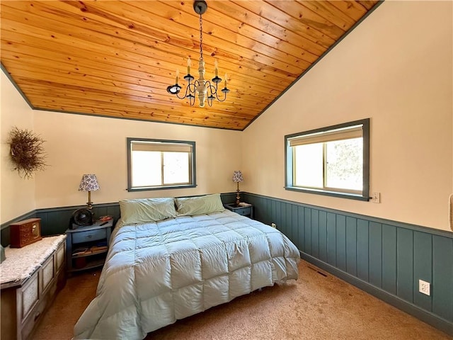 bedroom with wooden ceiling, a wainscoted wall, multiple windows, and lofted ceiling