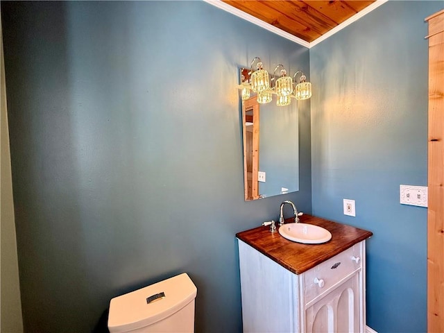 bathroom with toilet, crown molding, and vanity