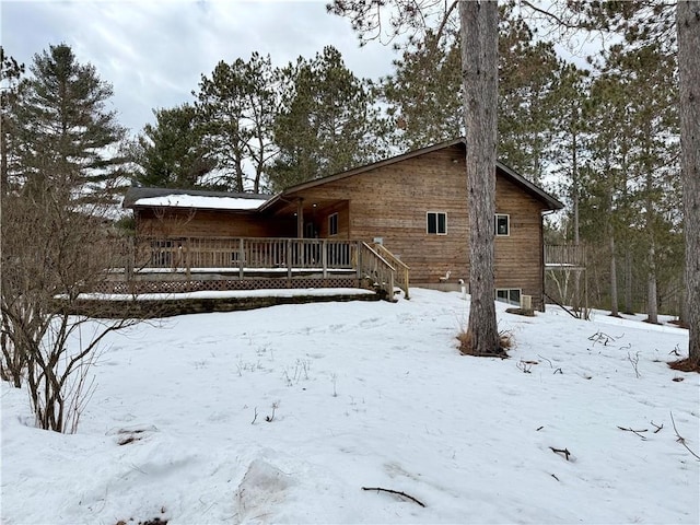 snow covered rear of property featuring a garage