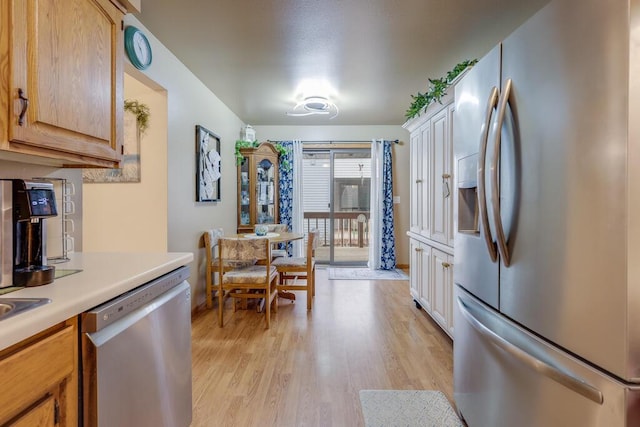 kitchen featuring appliances with stainless steel finishes, light countertops, and light wood-style floors