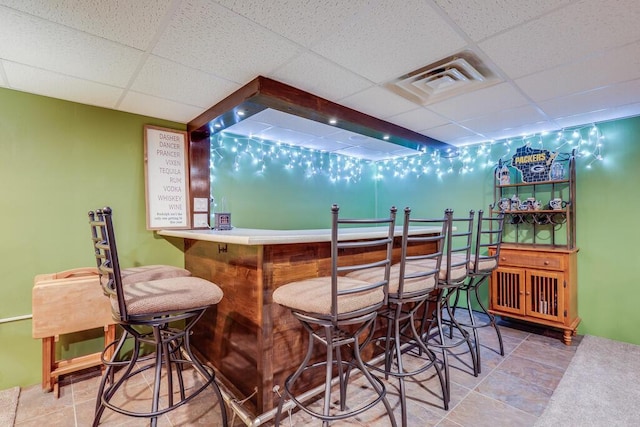 bar featuring a dry bar, a drop ceiling, and visible vents