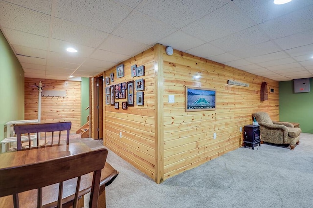 interior space featuring wood walls and a drop ceiling