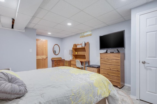 bedroom with a paneled ceiling, baseboards, and recessed lighting