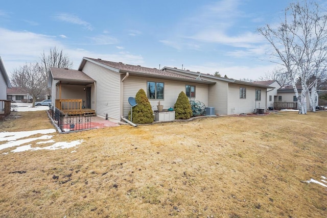 back of house featuring a lawn, central AC, and a patio