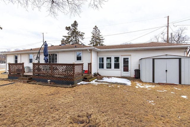 rear view of house with an outdoor structure, a chimney, a wooden deck, and a storage unit