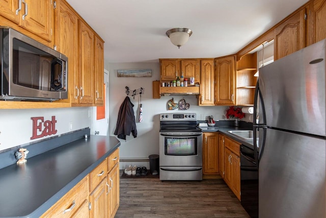 kitchen featuring dark countertops, brown cabinets, stainless steel appliances, and dark wood finished floors